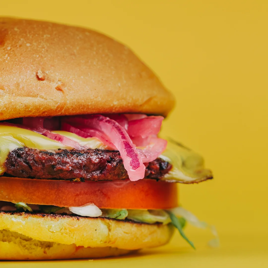 Nhdesign project SMASH VS THREAT: Sneaky Smash burger with beef, red onion, and sauce on orange background