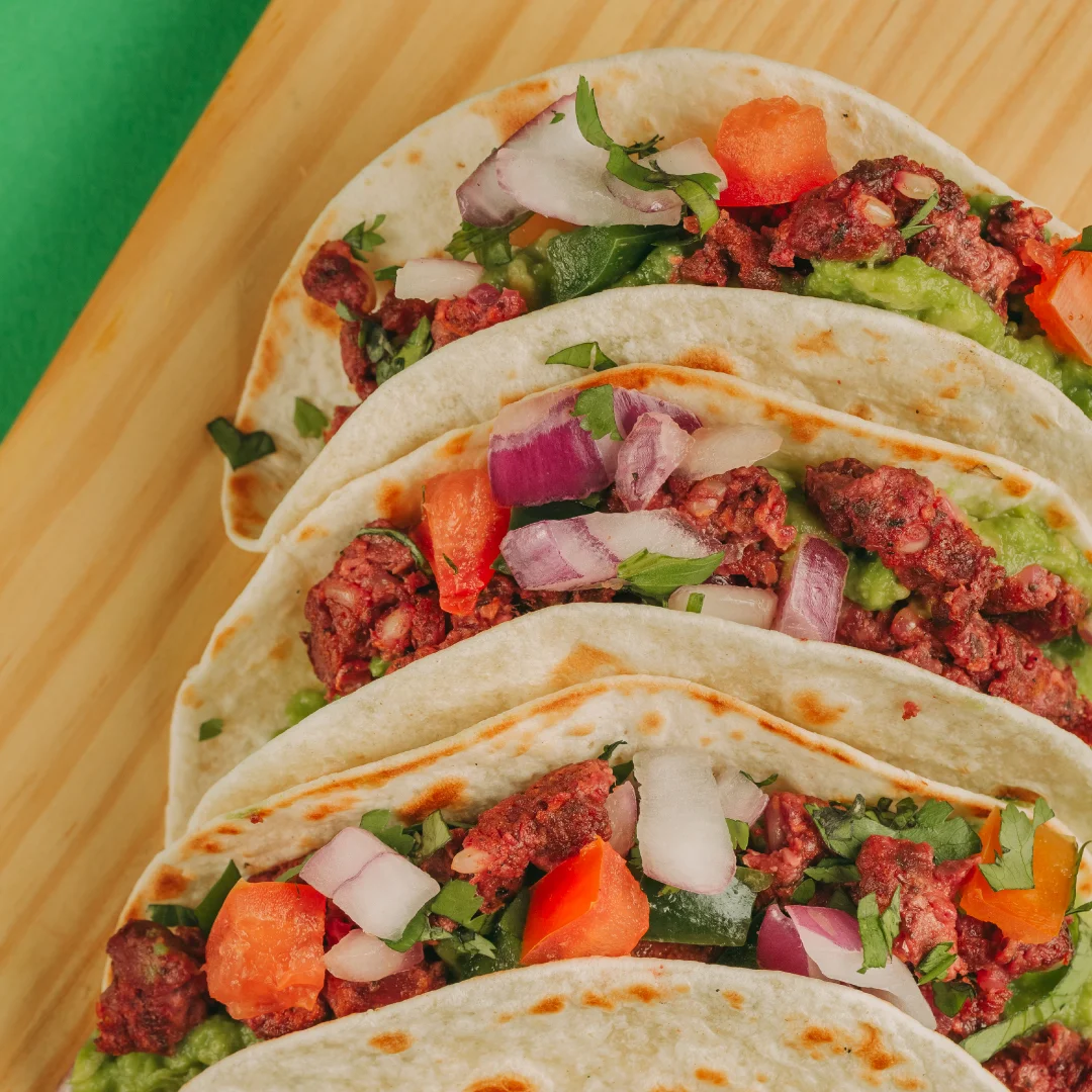 Nhdesign project SMASH VS THREAT: Tacos filled with meat, tomato, and lettuce served on wooden plate