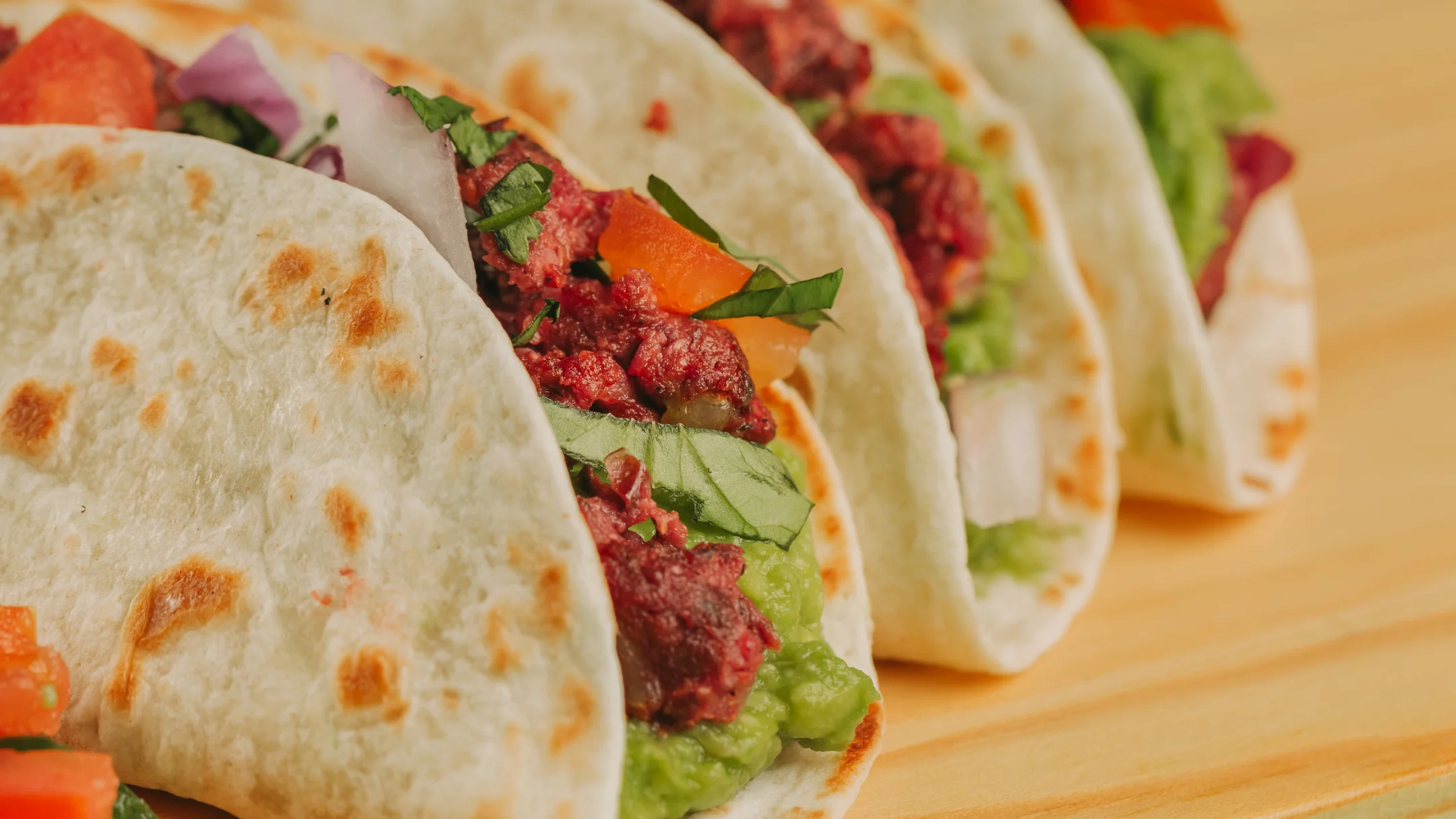Nhdesign project SMASH VS THREAT: Tacos filled with meat and vegetables on light background