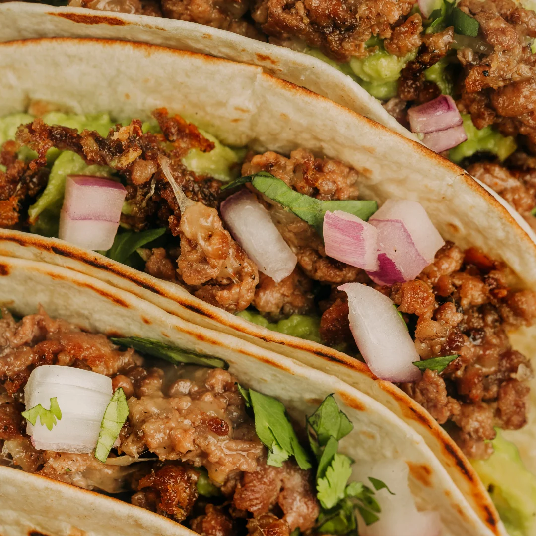Nhdesign project SMASH VS THREAT: Tacos filled with meat, onion, and cilantro served on plate