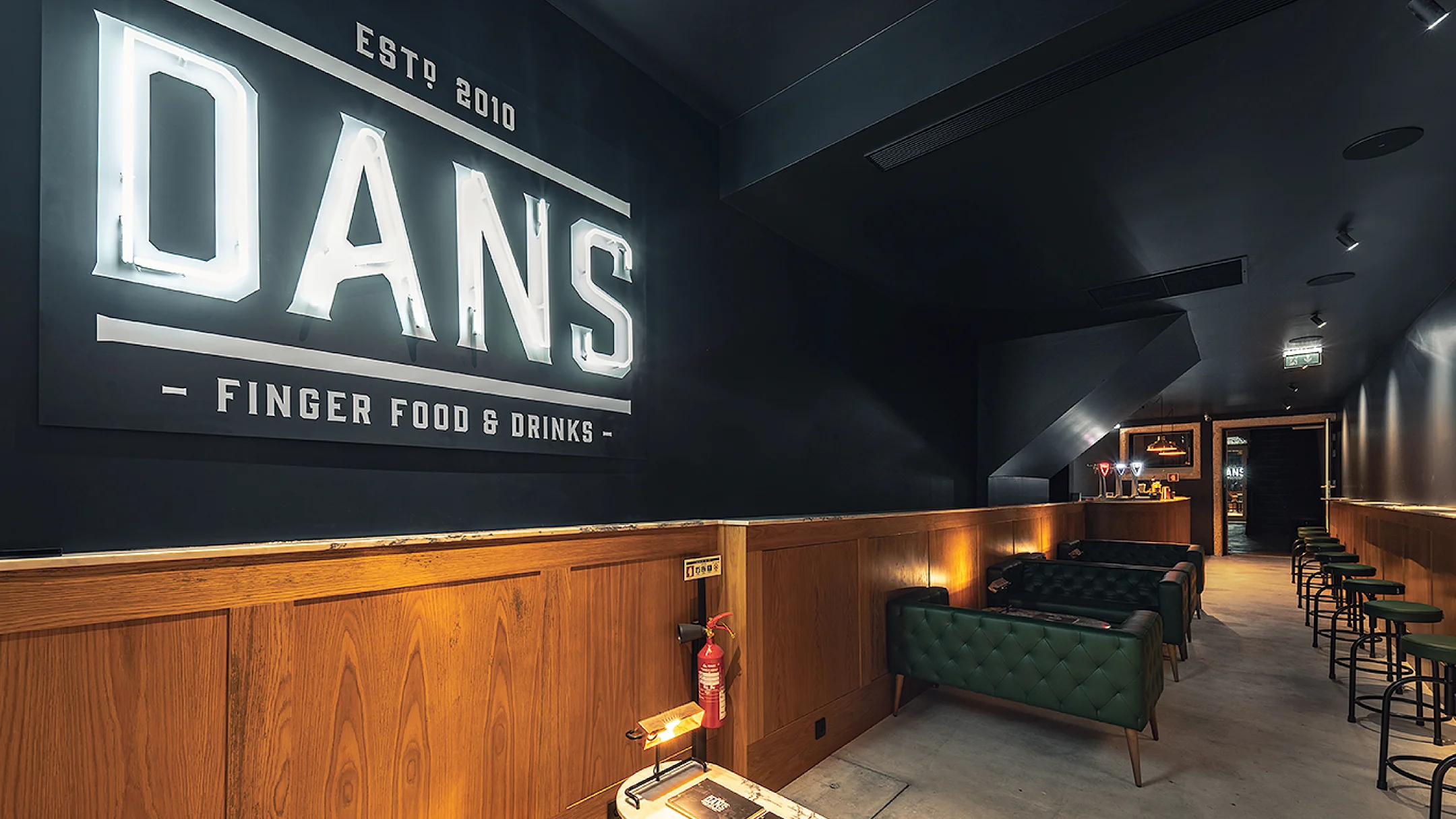 Nhdesign project DANS: Entrance of DANS restaurant with illuminated logo on facade