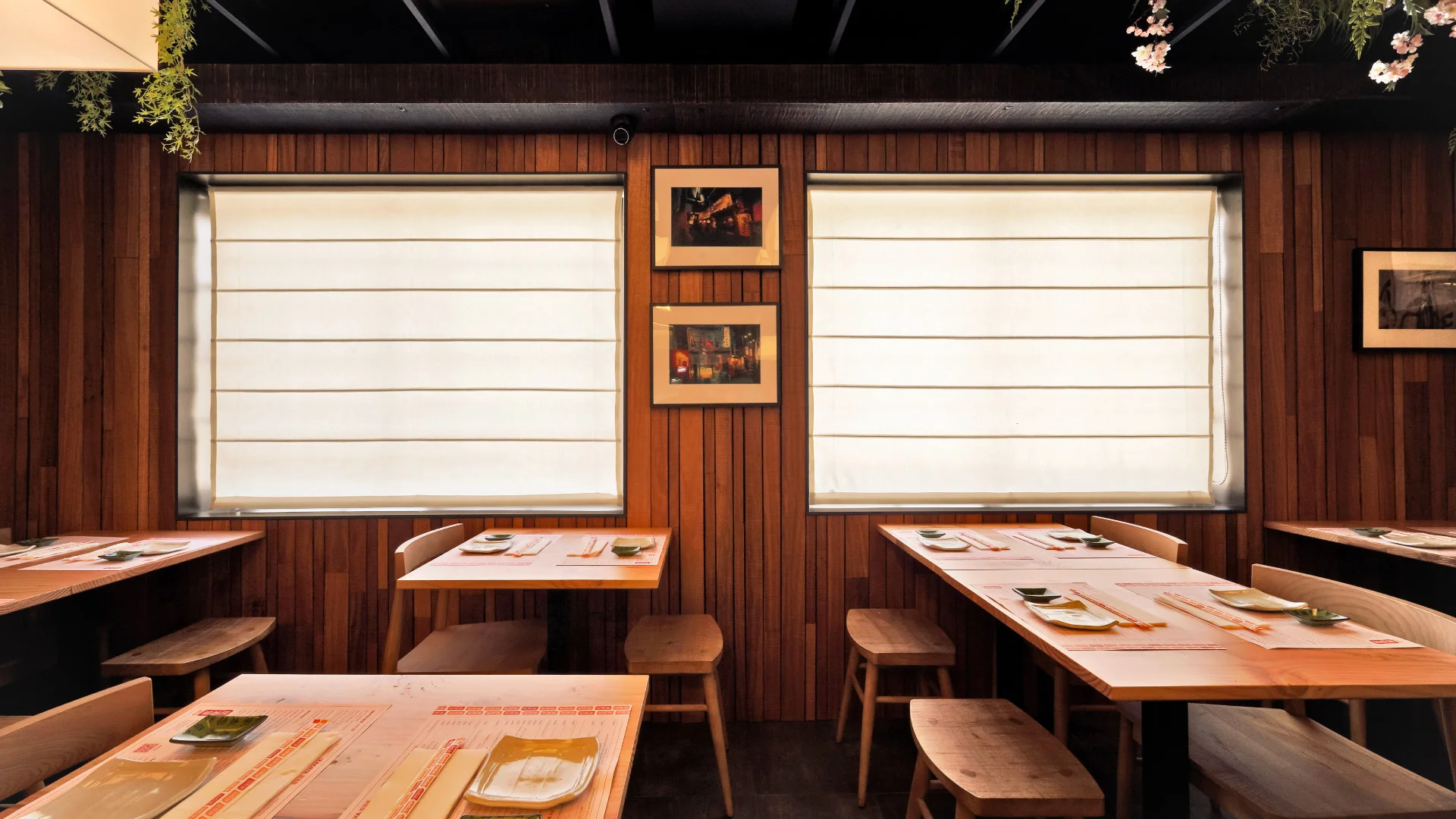 Nhdesign project Izakaya Matsuri: Interior of a restaurant with tables and chairs arranged neatly in front of a large window.