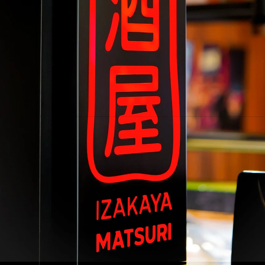 Nhdesign project Izakaya Matsuri: Close-up Photograph of a glowing logo sign on a bar counter