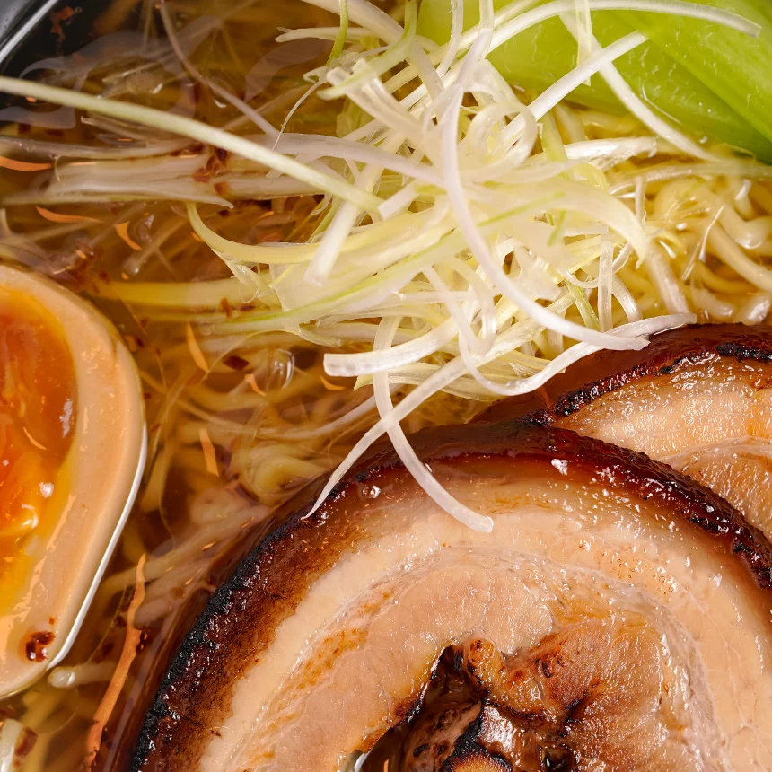 Nhdesign project Izakaya Matsuri: Close-up Photograph of a bowl of ramen topped with meat and mixed vegetables on wooden table.