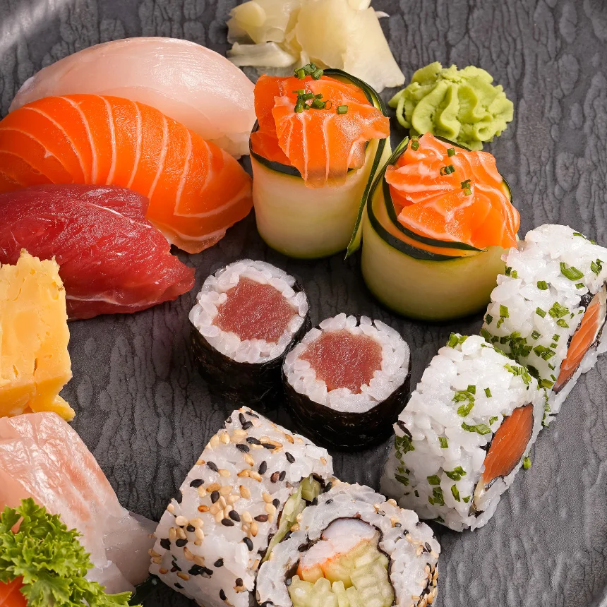 Nhdesign project Izakaya Matsuri: Close-up Photograph of an elegant black plate filled with a variety of sushi and other Asian dishes.