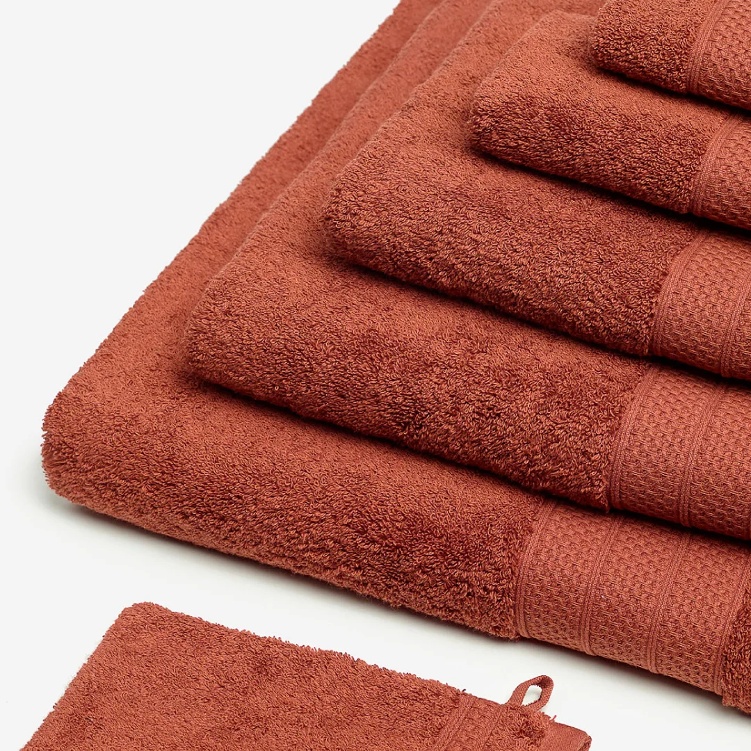 Nhdesign project Kazley: Set of folded red Kazley towels on neutral background