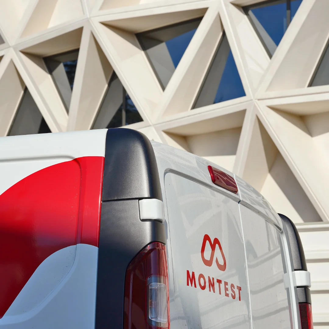 Nhdesign project Montest: Montest vehicle with logo in front of modern building.