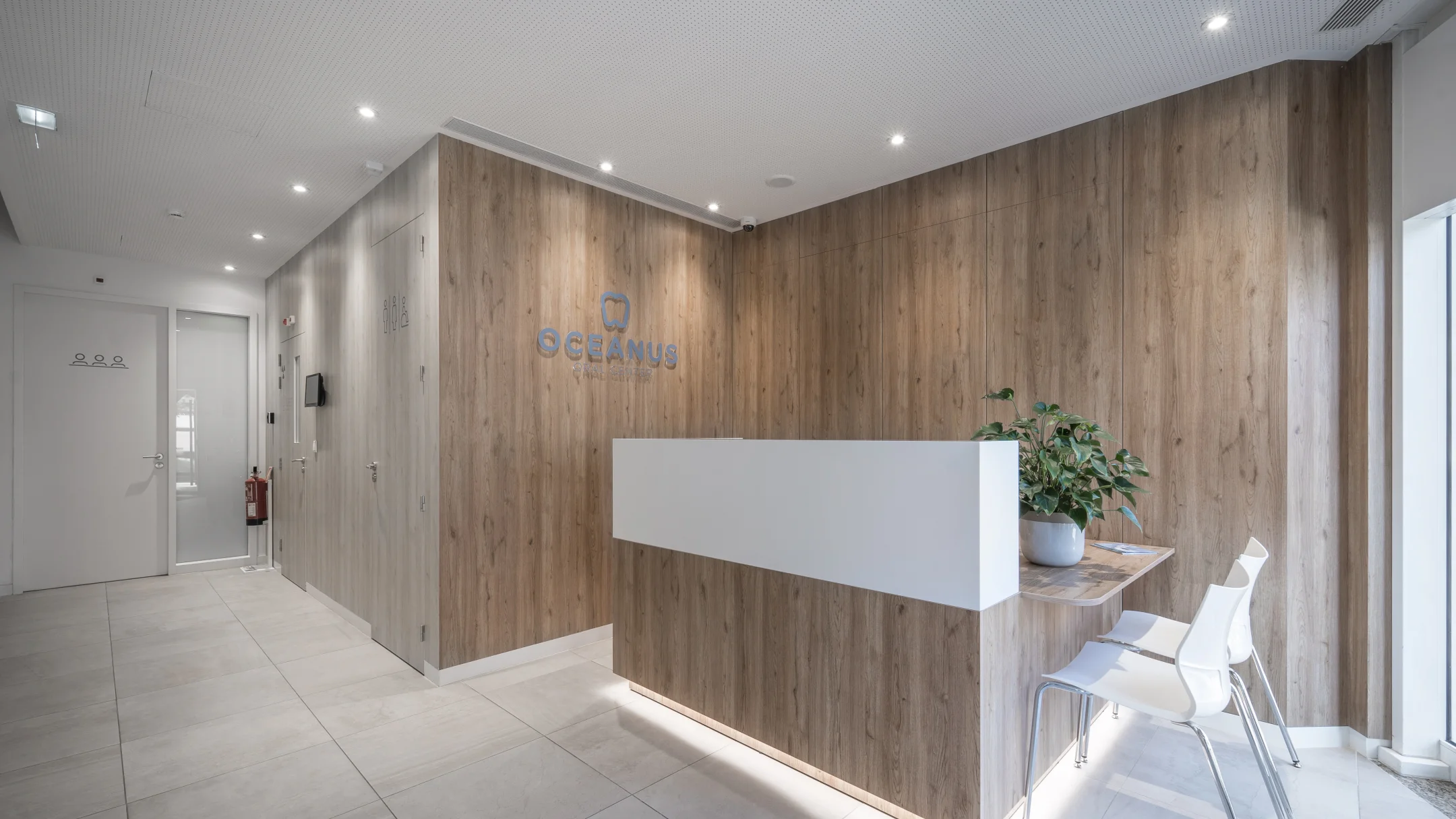 Nhdesign project OCEANUS: Reception area of Oceanus Oral Center clinic with wood and white counter