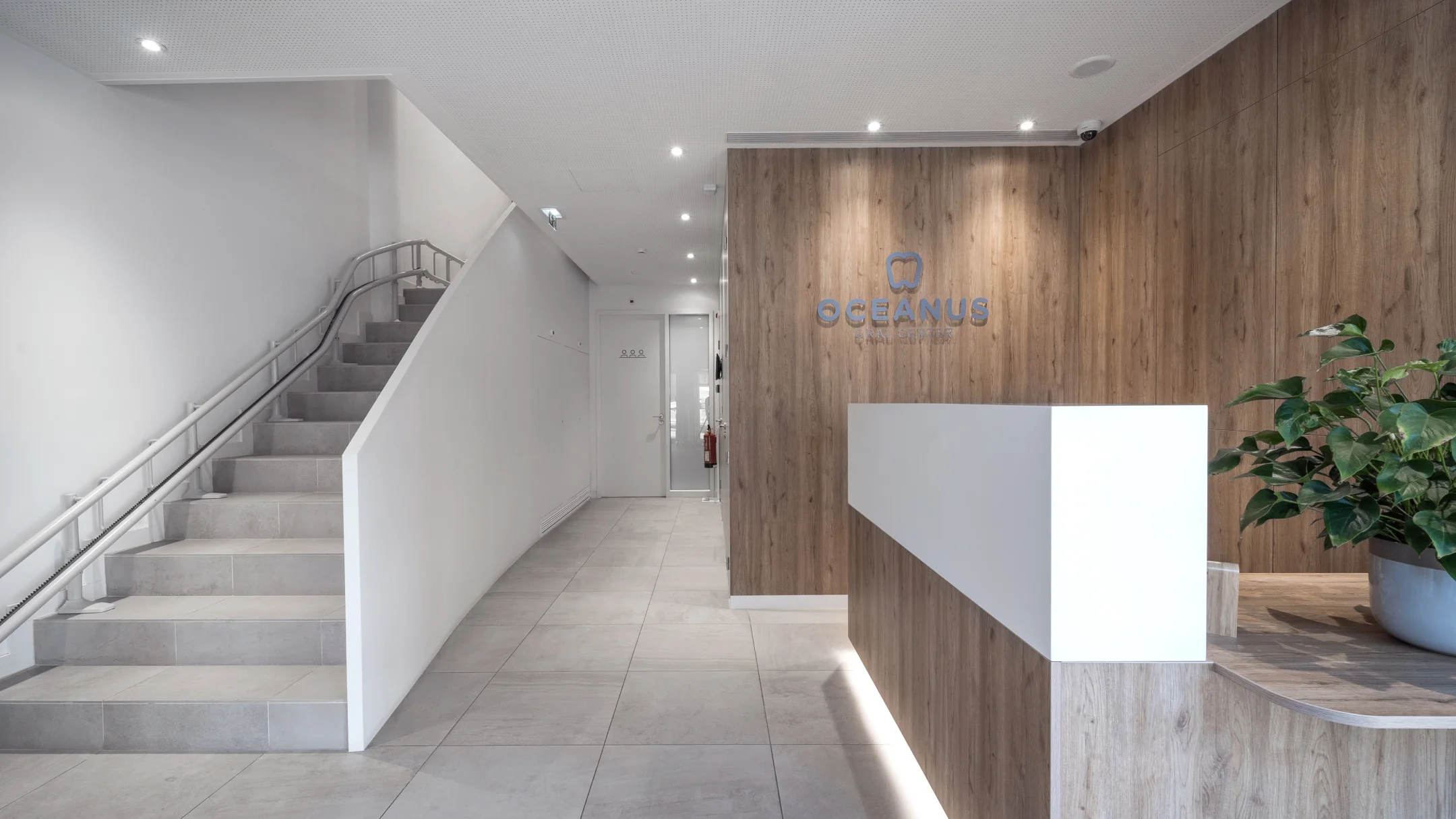 Nhdesign project OCEANUS: Oceanus Oral Center reception area with modern wooden and white stairs